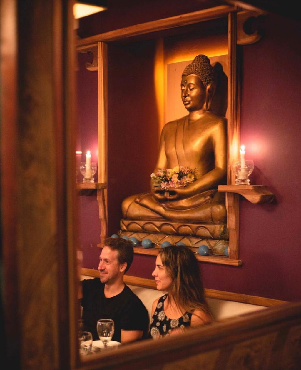 personas cenando con buda